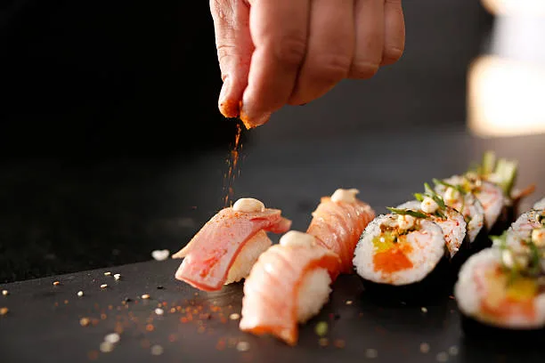 Chef preparing a piece of sushi by hand